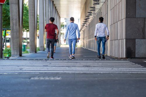 tres hombres cruzando la calle