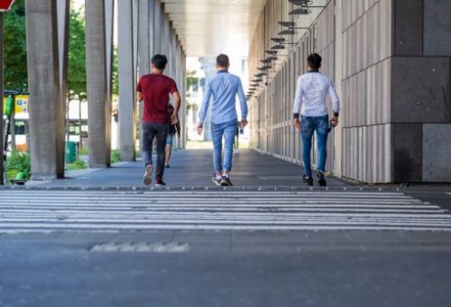 tres hombres cruzando la calle